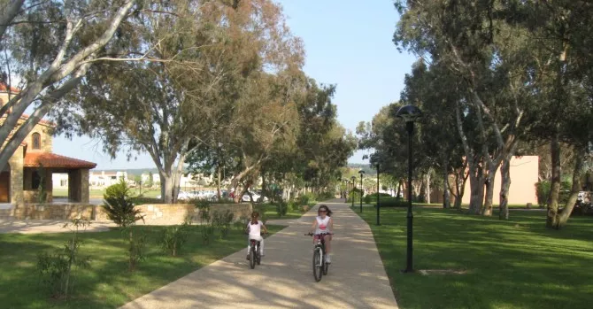 Sani Resort i deca voze bicikl pored crkve