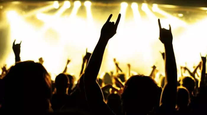 Mladi na koncertu uzdižu ruke koje simbolizuju znaj Satane - uzdignut kažiprst i mali prst, rogovi djavola. Malo ko od njih je svestan šta radi