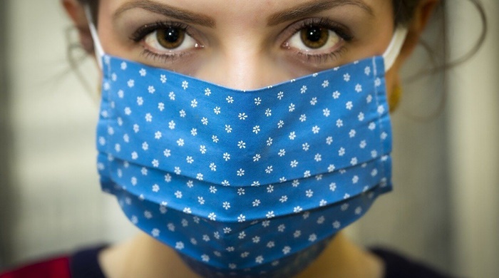 Devojka na čijem se licu nalazi plava zaštitna maska